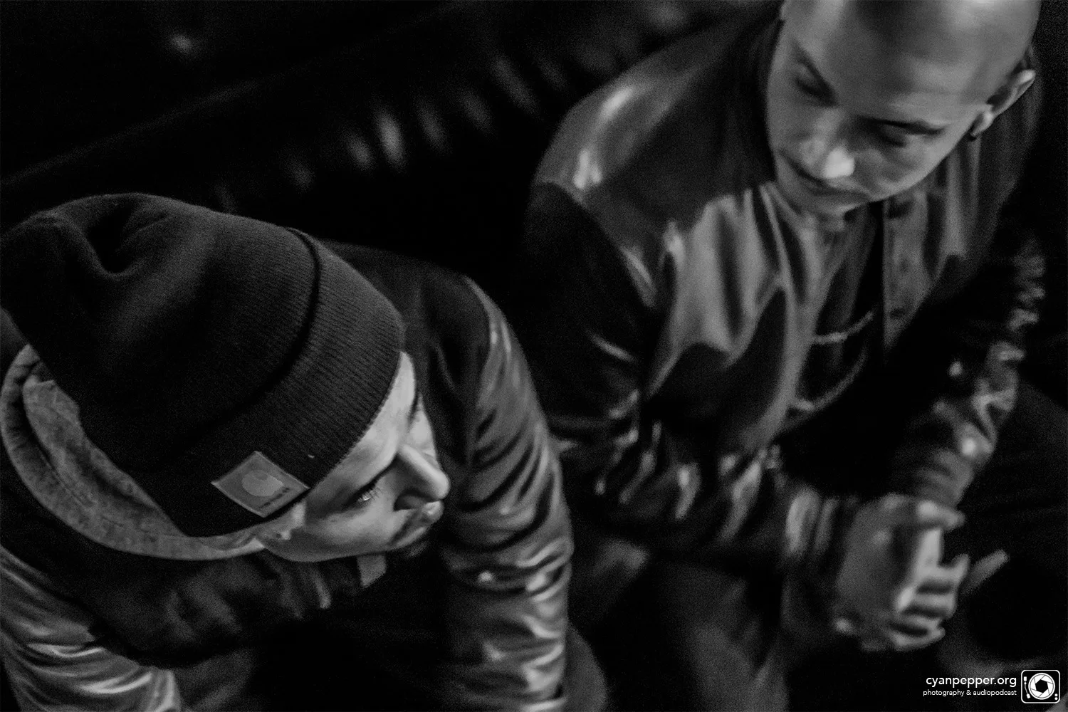 A DJ leaning over the decks, shot in black and white